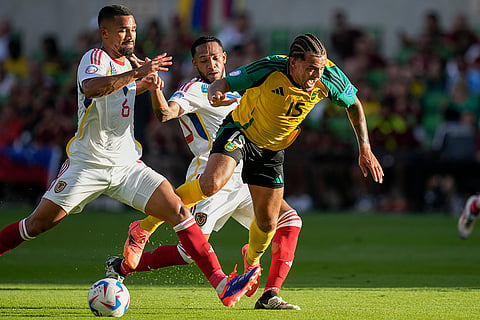 Joel Latibeaudiere is tripped up by Venezuela's Yangel Herrera